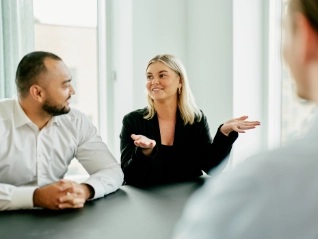 Woman Explaining something to two men in a meeting room