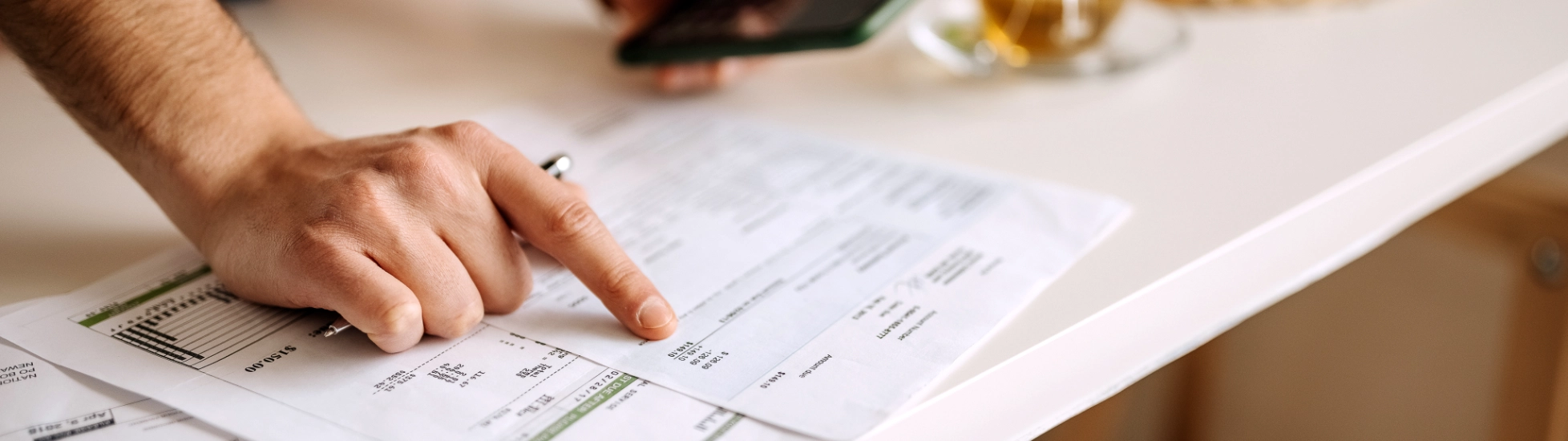 hands pointing at sheet and holding mobile