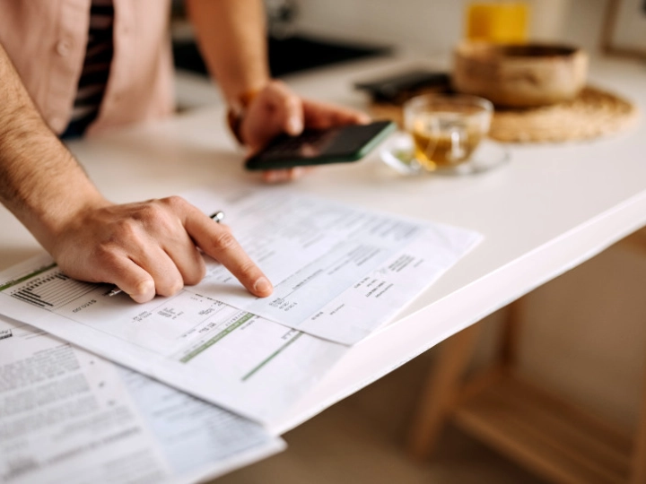 hands pointing at sheet and holding mobile image